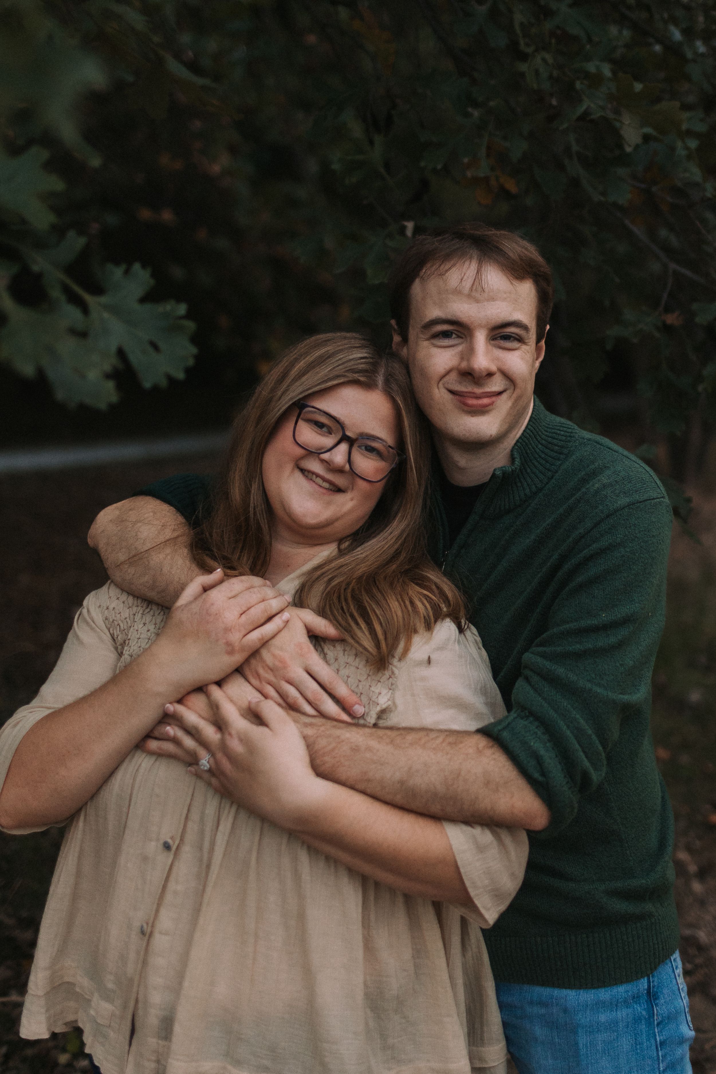 A joyful couple embraces and laughs together during their outdoor photo session.