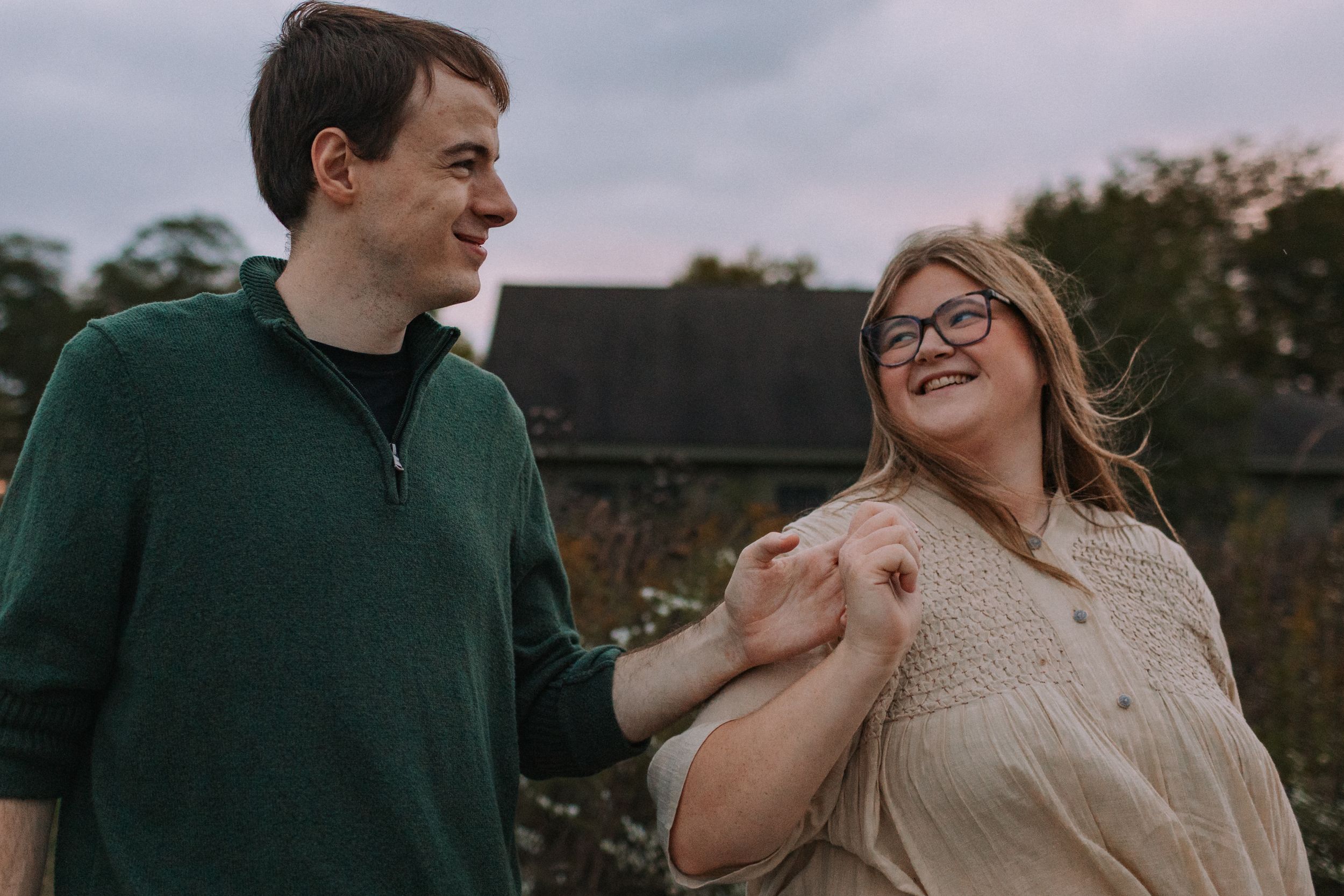 Candid moment of joy captured between a couple in casual attire outdoors.