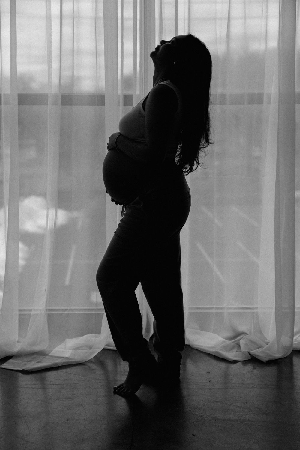 Pregnant women embracing her belly during a maternity session at Bloom Studio in Rochester, NY