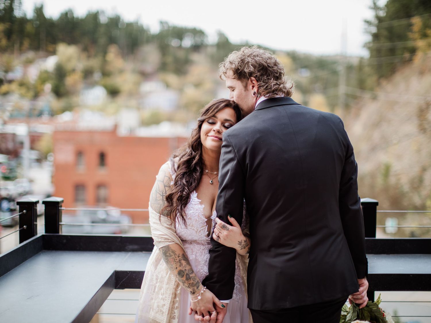 Romantic moment shared on urban rooftop with city views at sunset.