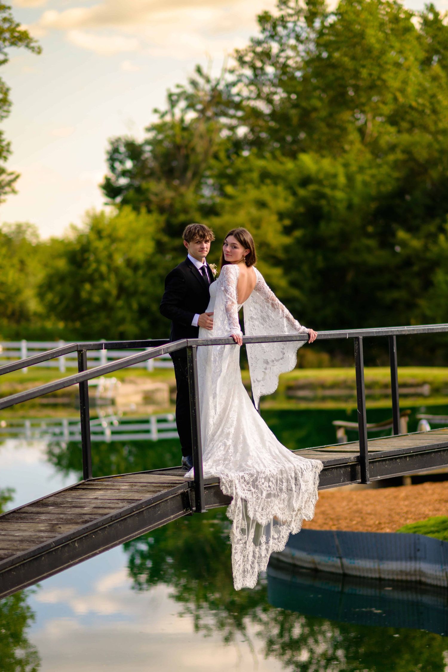 Beautiful wedding couple cuddling on bridge