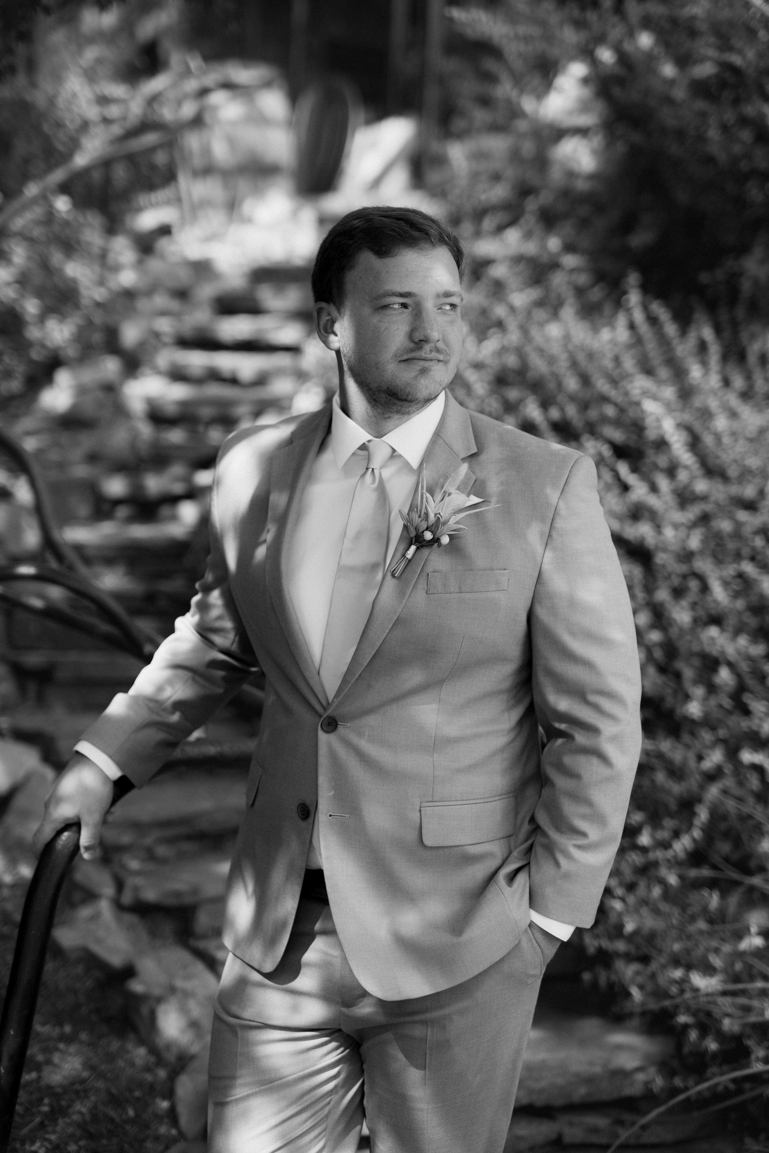 Portrait series of person in light gray suit against natural outdoor background.