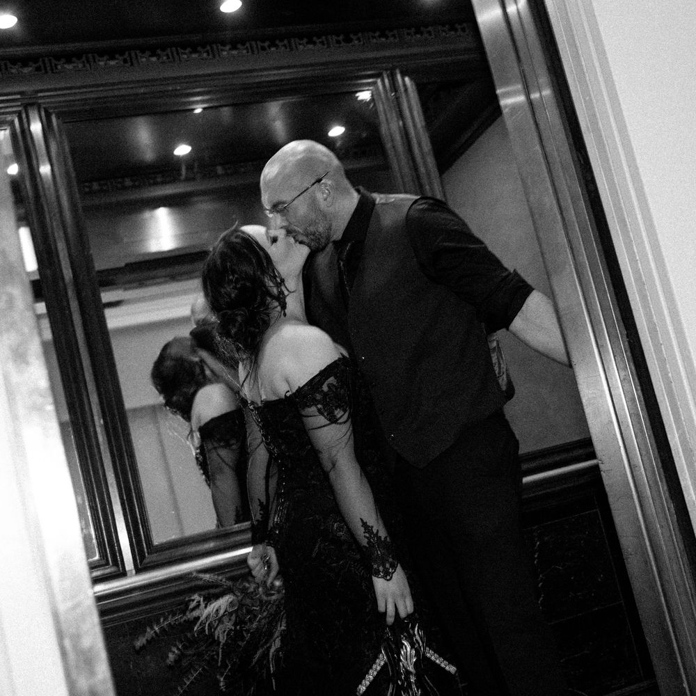 An elegant couple sharing an intimate dance moment in formal attire captured in black and white photography.