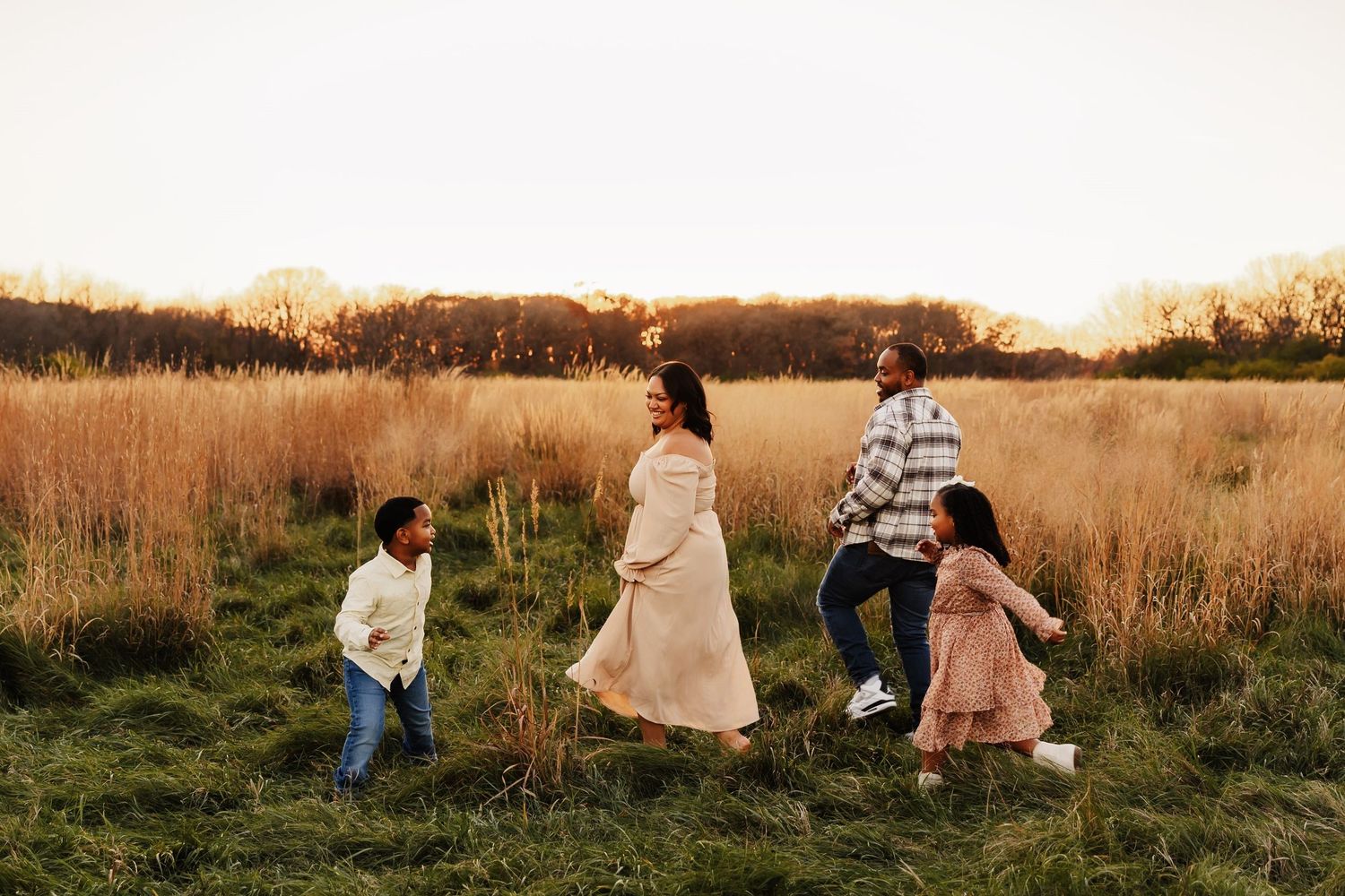 Happy family playing with their children on the summer green grass in Naperville, Illinois.