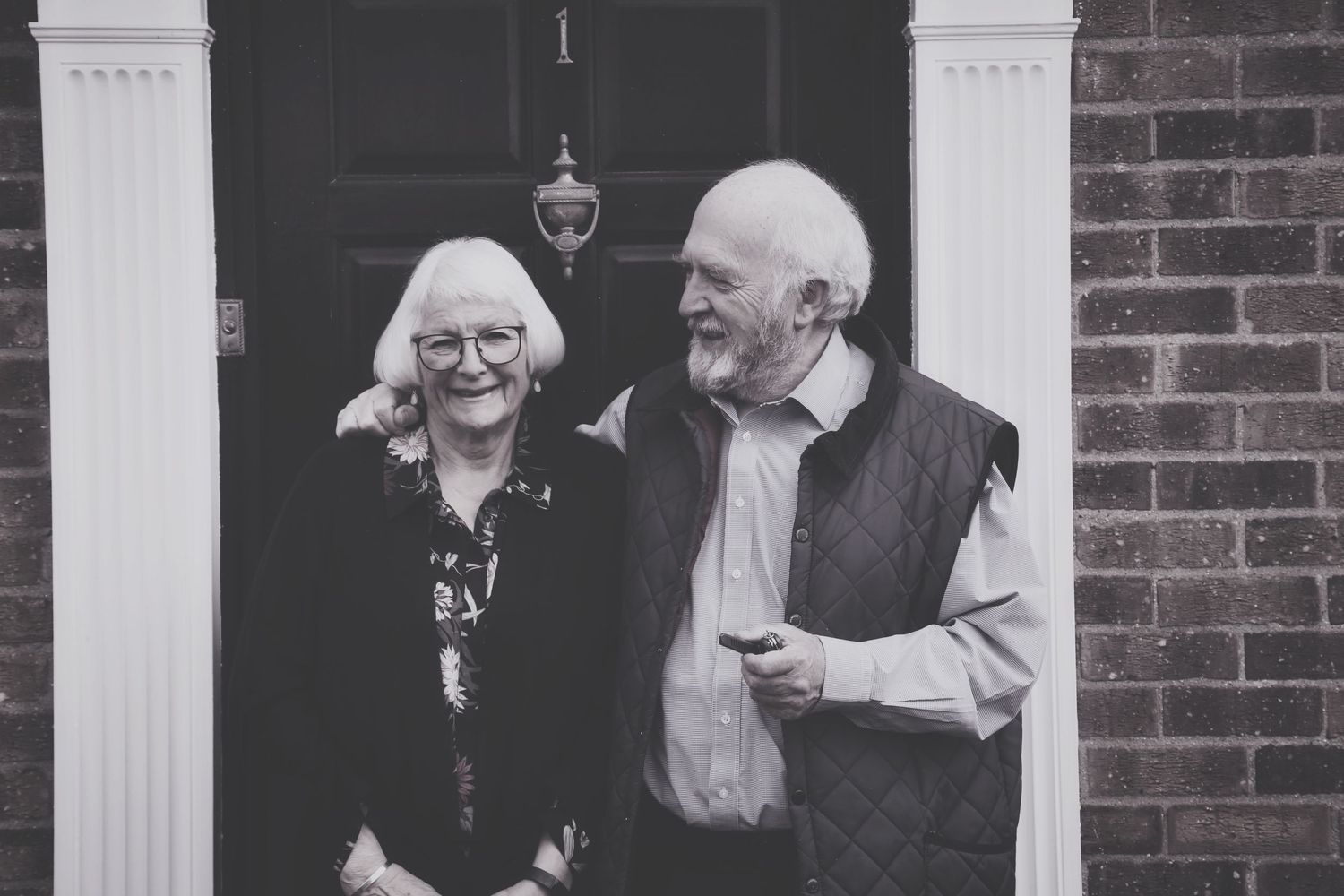 Black and white photo of people socializing on brick house porch. Photographer. Hull. East Yorkshire. Photography