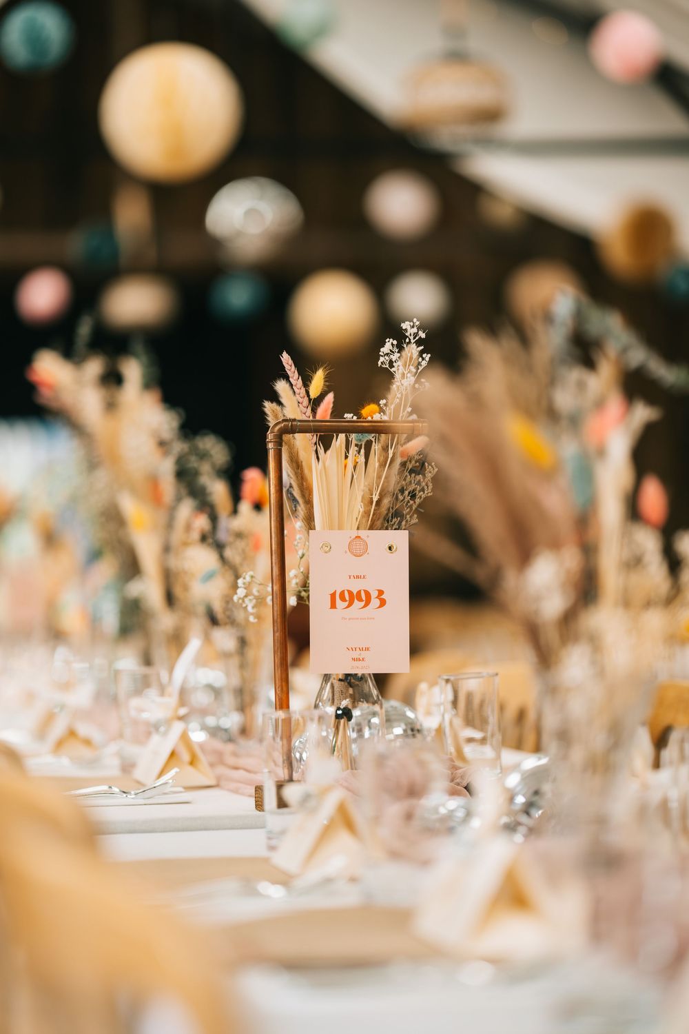 Elegant wedding reception table settings with vintage decor and soft lighting create a romantic atmosphere.
