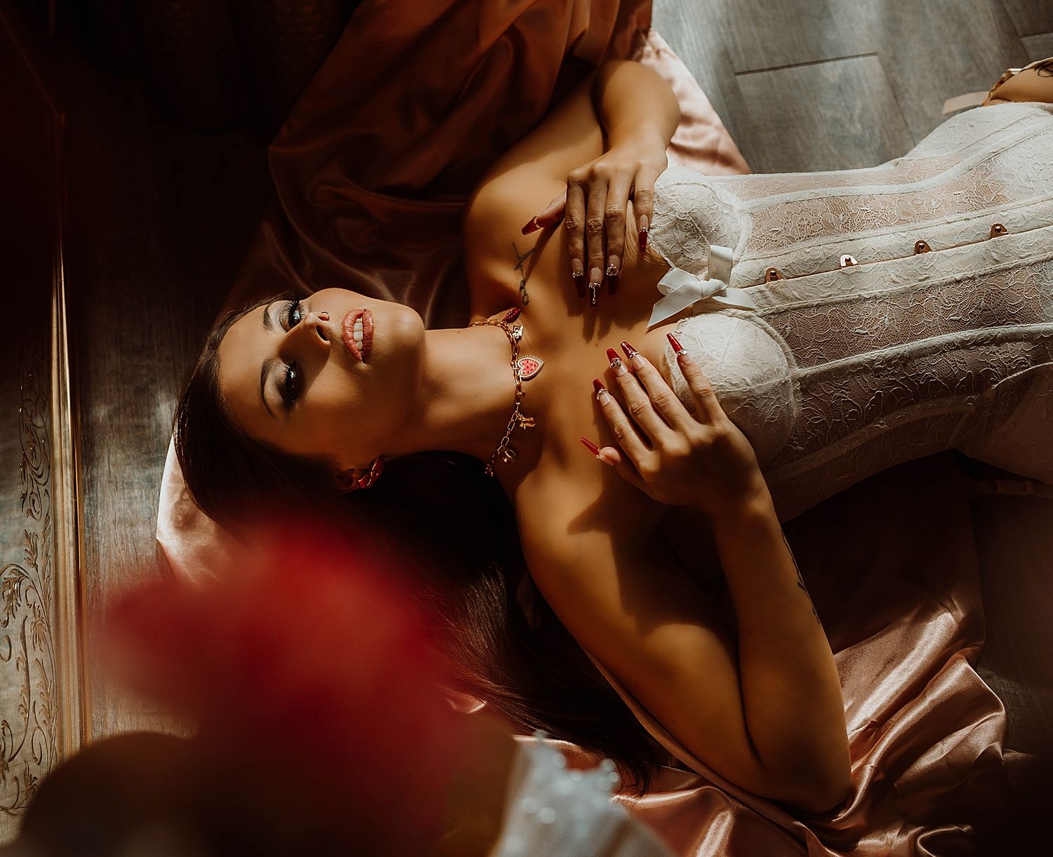 Woman with charm necklace on studio floor by Boudoir by KJ.