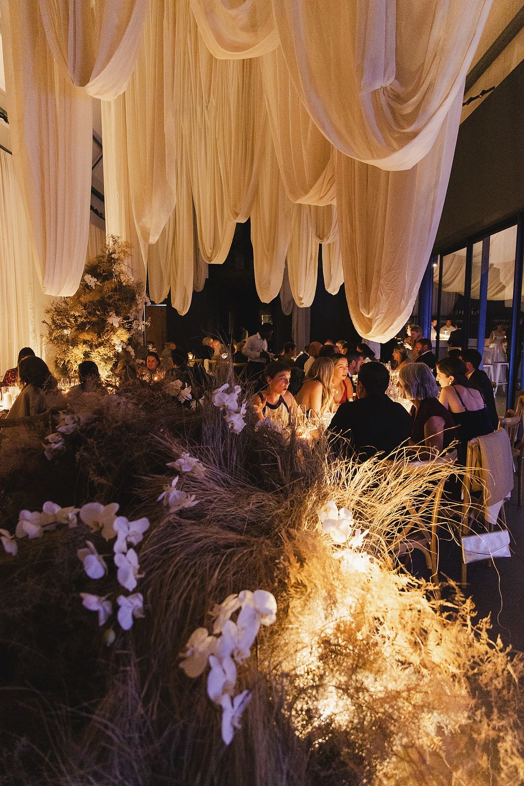 Guests seated under white draping at the reception area.
