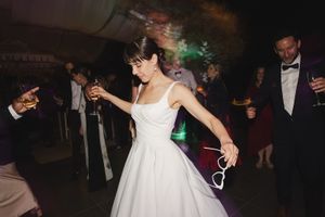 Bride dancing on dancefloor with guests.