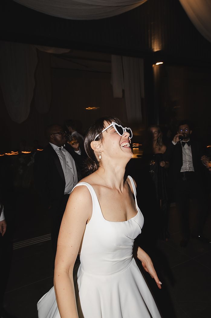 Bride enjoying some fun with sunglasses on the dancefloor.