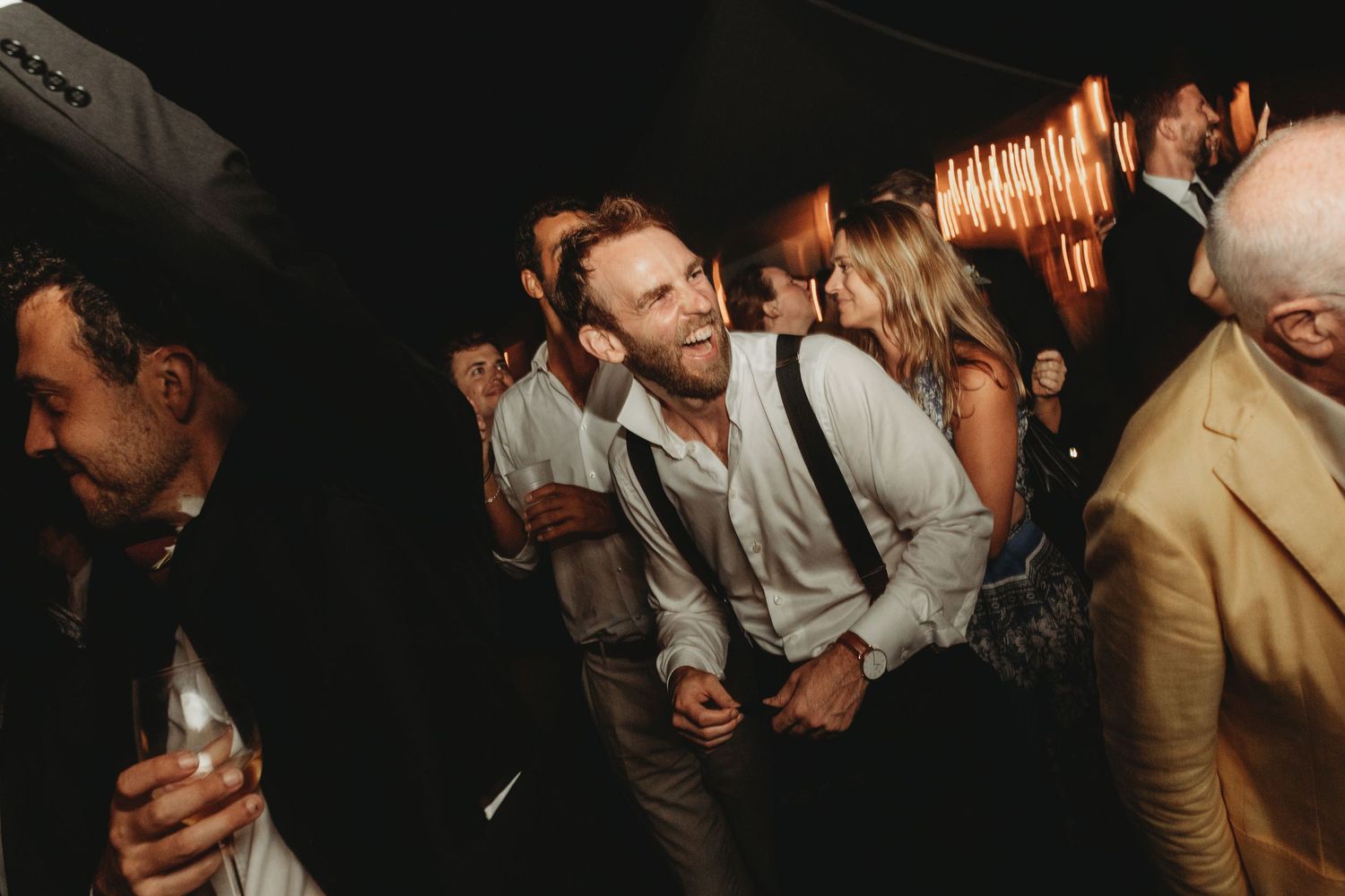 Partygoers dancing and socializing in a dimly lit indoor venue with a festive atmosphere.