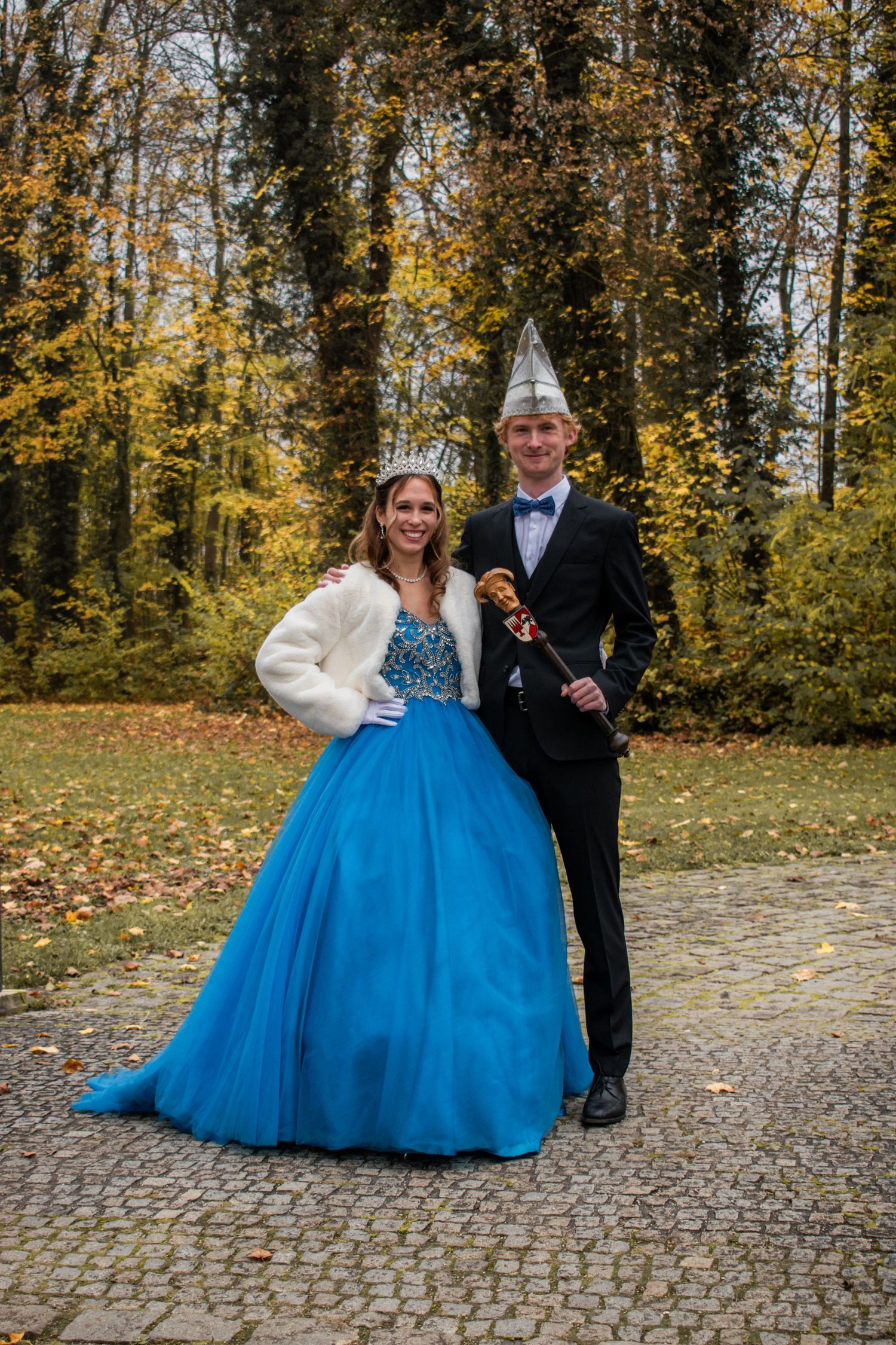 Formal portrait in autumn setting with blue ballgown and traditional festive attire.