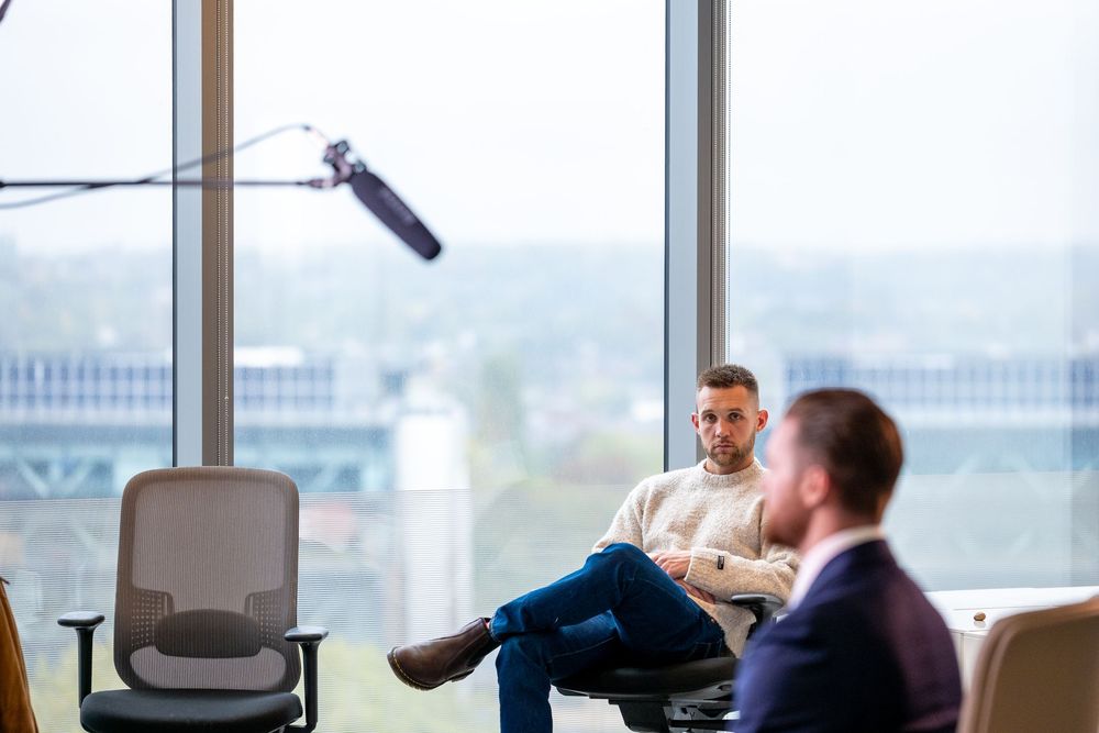 Camera operators prepare equipment for a professional video shoot in a corporate environment.