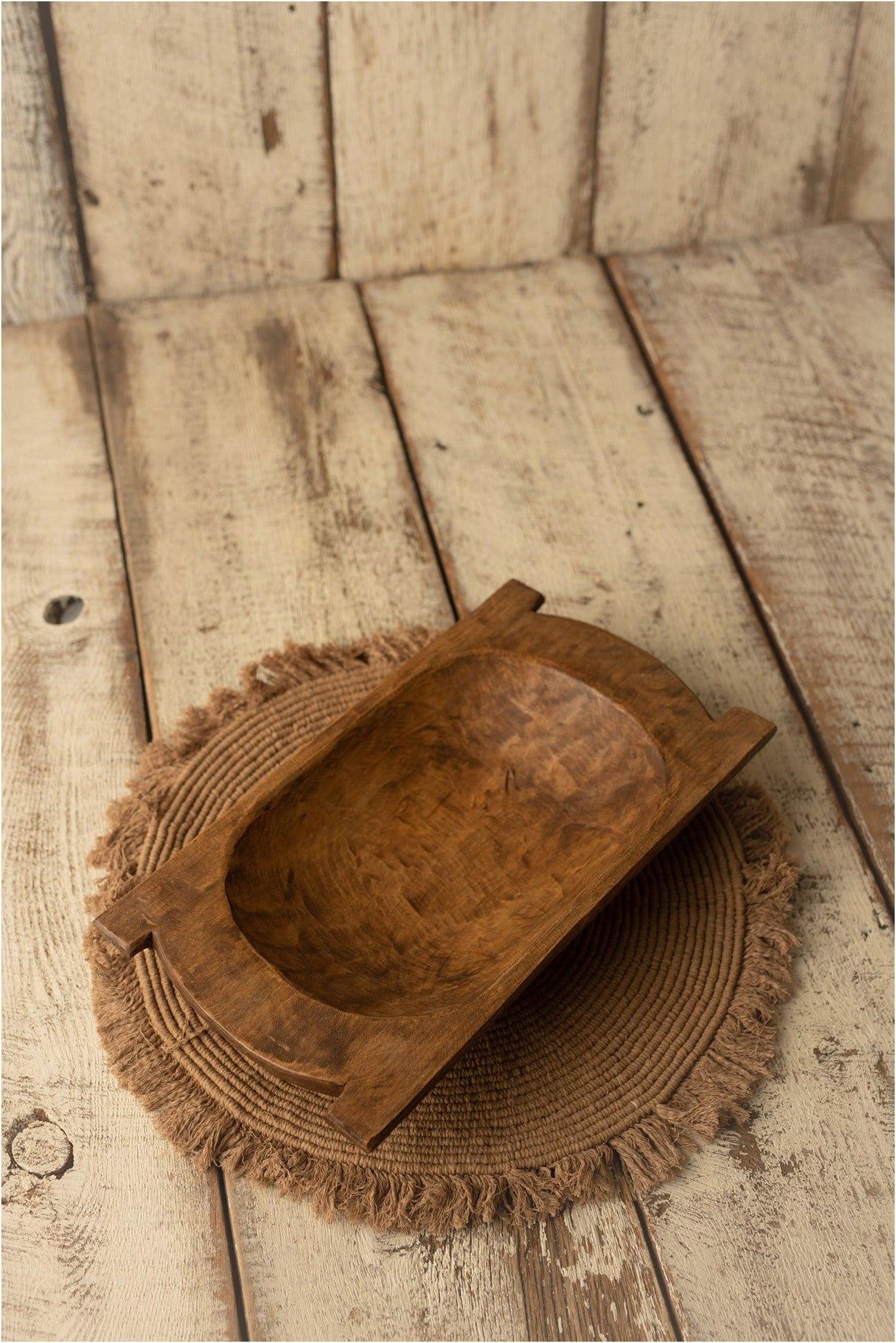 Multiple views of a weathered brown leather baseball glove resting on a rustic wooden surface.