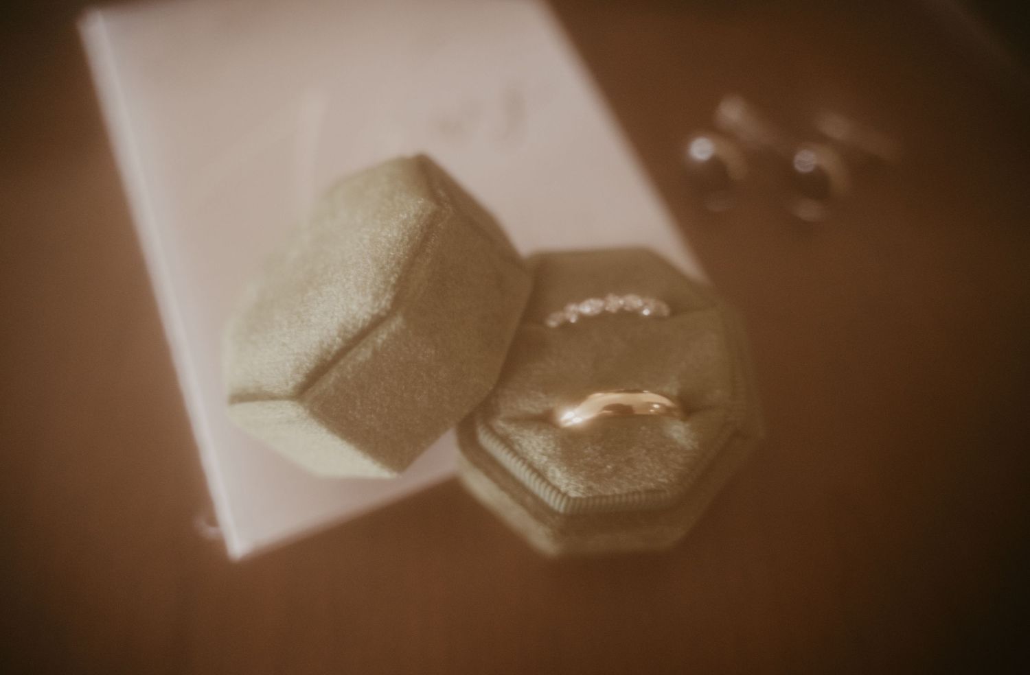 Close-up shot of wedding rings in moody lighting creating an artistic silhouette effect.