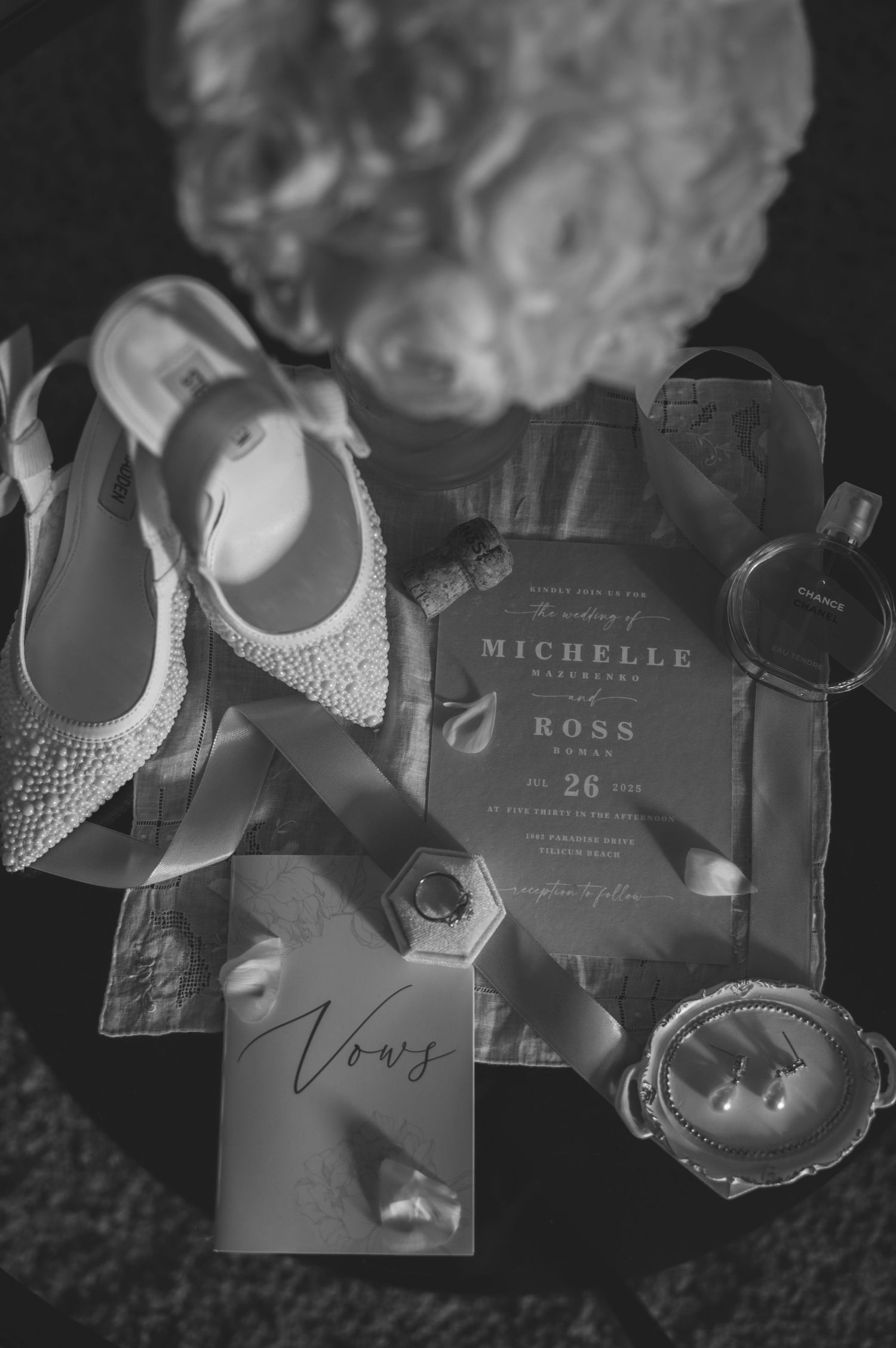 Wedding invitation cards and decorative elements arranged artistically in black and white tones.
