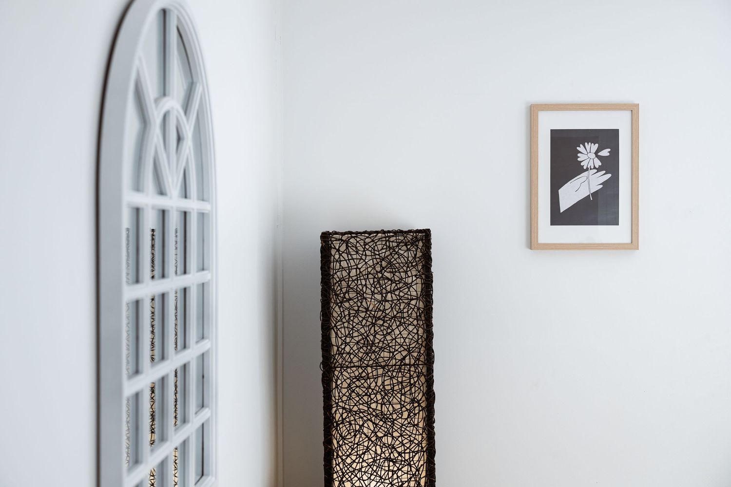 A series of minimalist white walls with small framed artwork and photographs displayed in a gallery-like setting.