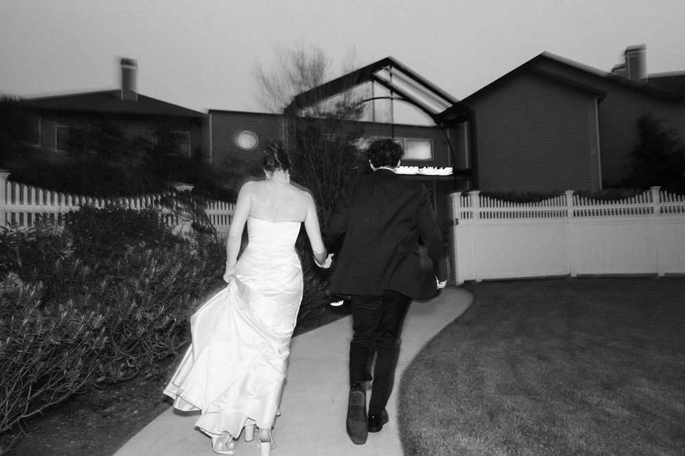 A series of black and white security camera footage stills showing movement in a residential driveway at night.