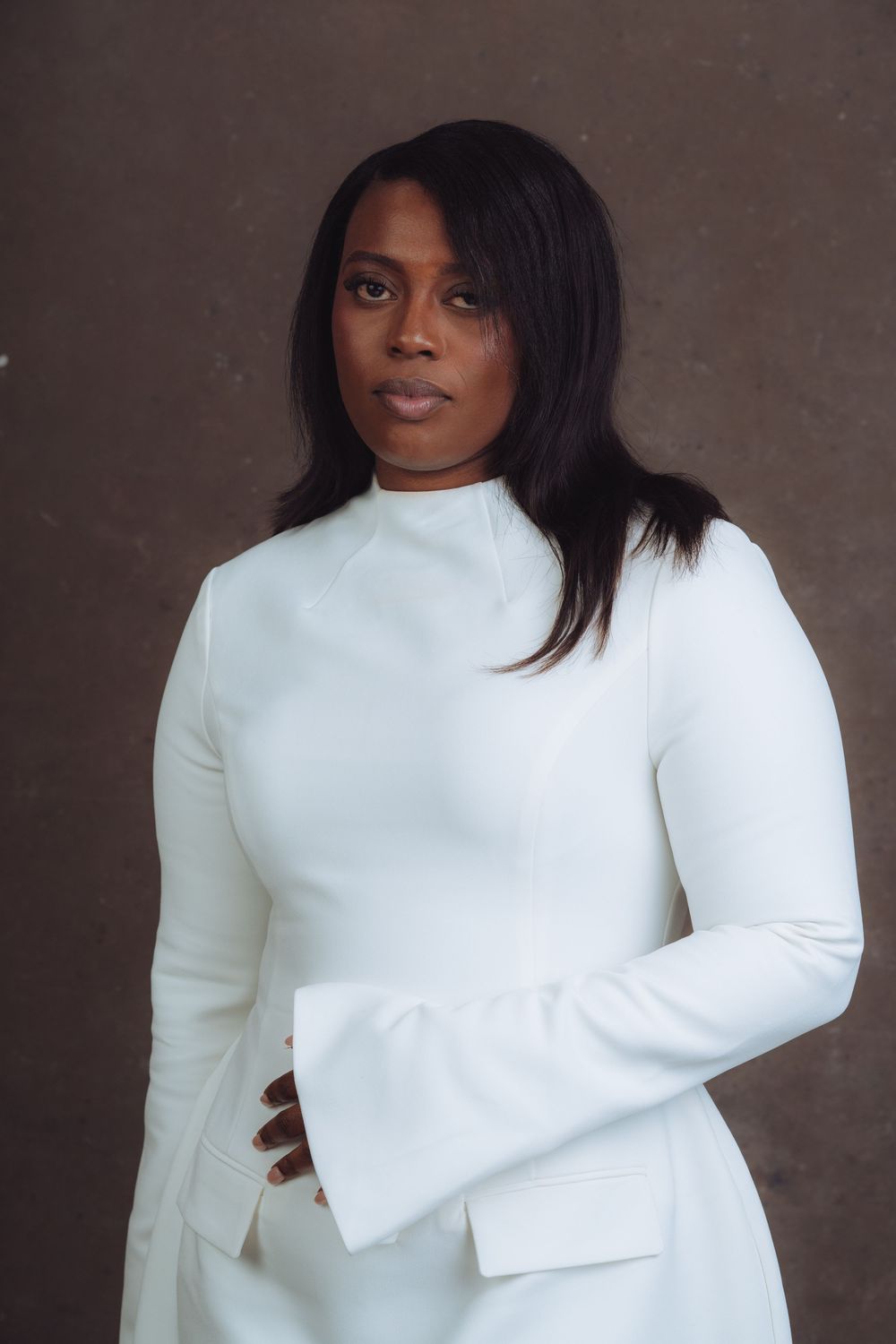 Fashion portrait in white sweater against dark background showing elegant styling and dramatic contrast.
