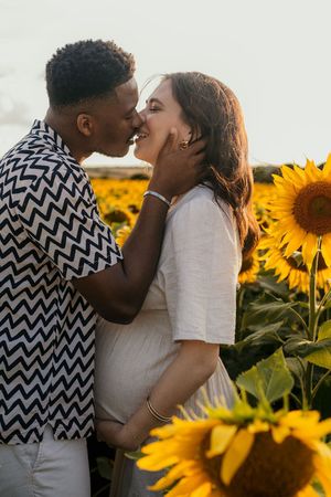Couple s'enlaçant dans les tournesols pendant la golden hour dans les yvelines