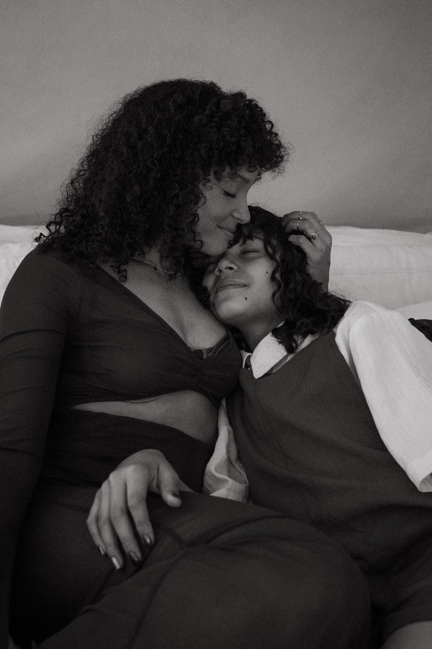 Intimate black and white photography series of two people embracing on a bed.