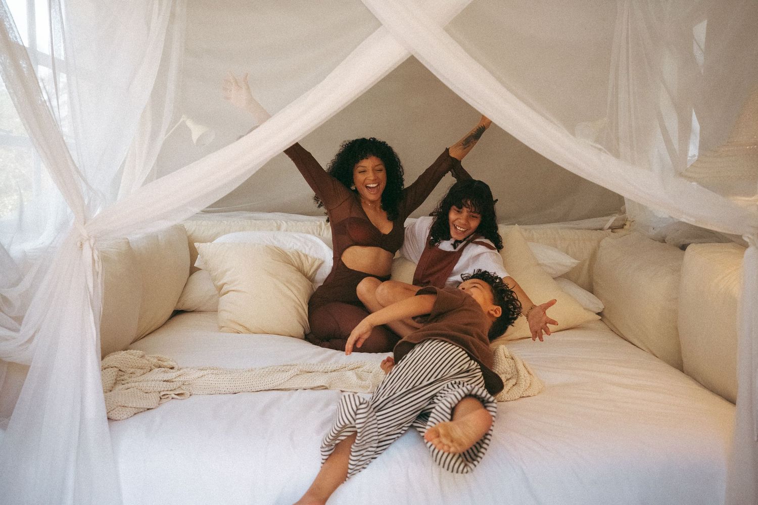 Dreamy bedroom scene with white canopy and soft natural lighting.