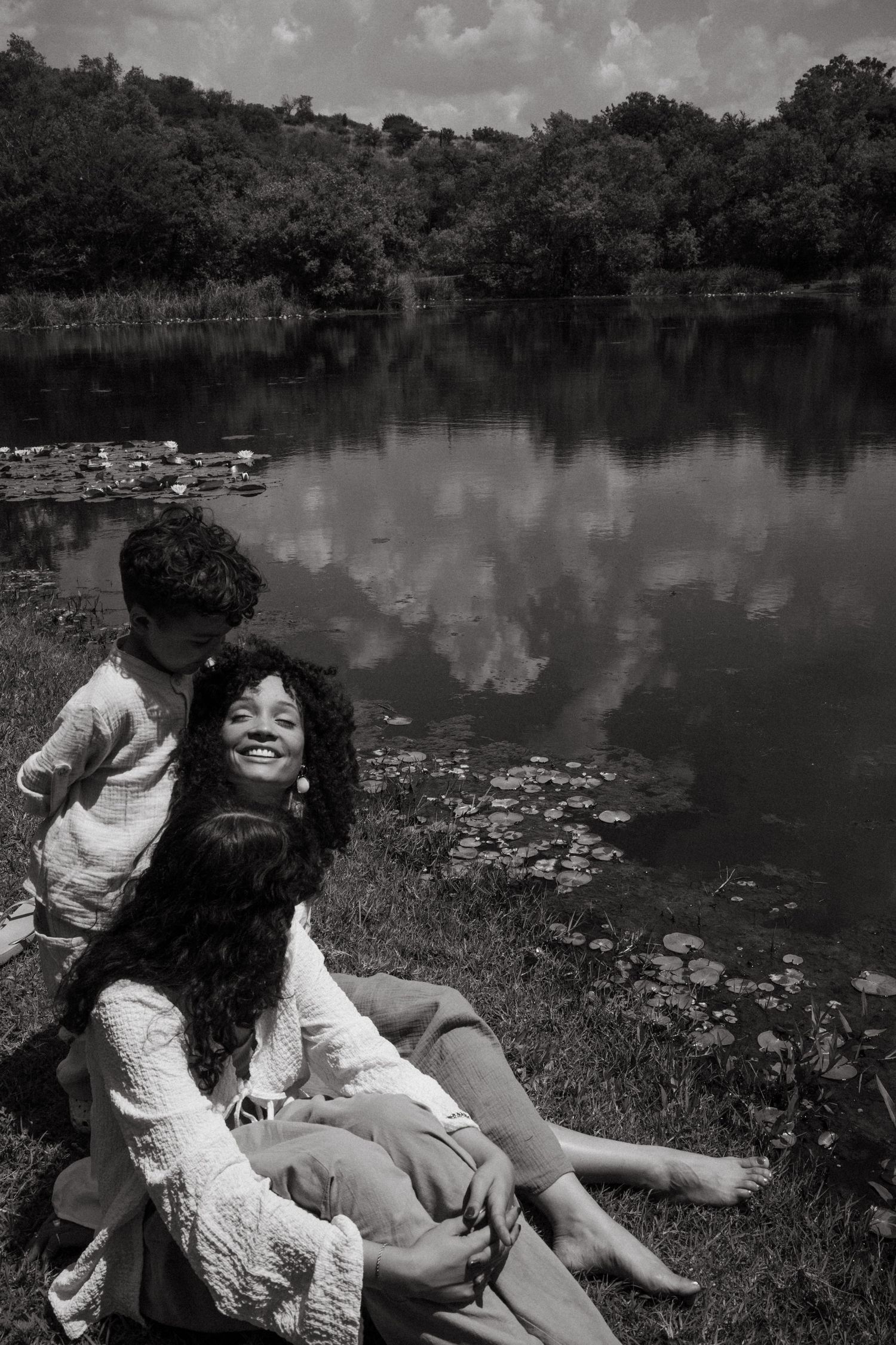 Scenic lakeside photoshoot with lily pads and reflective water in black and white.