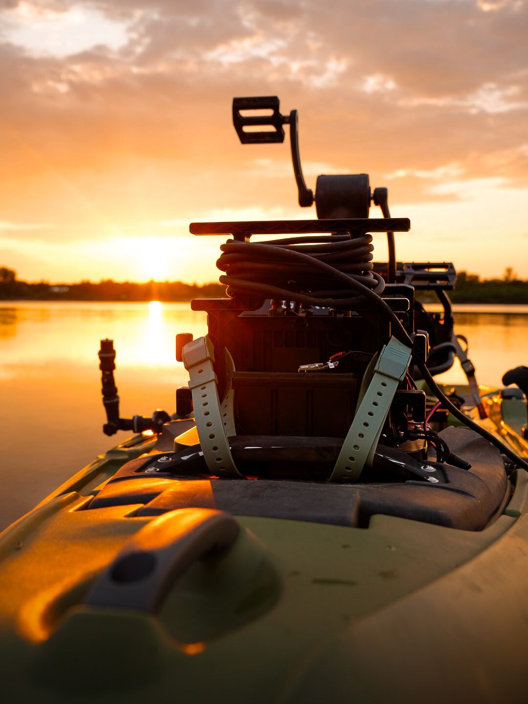 Camera equipment silhouetted against a dramatic orange sunset over water.