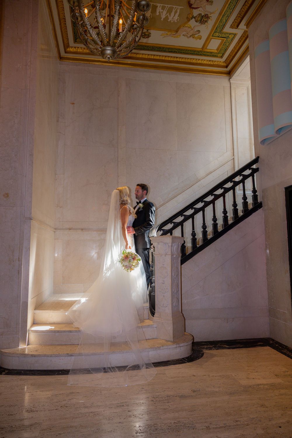 Bride and groom in staircase with light shining through in Miami