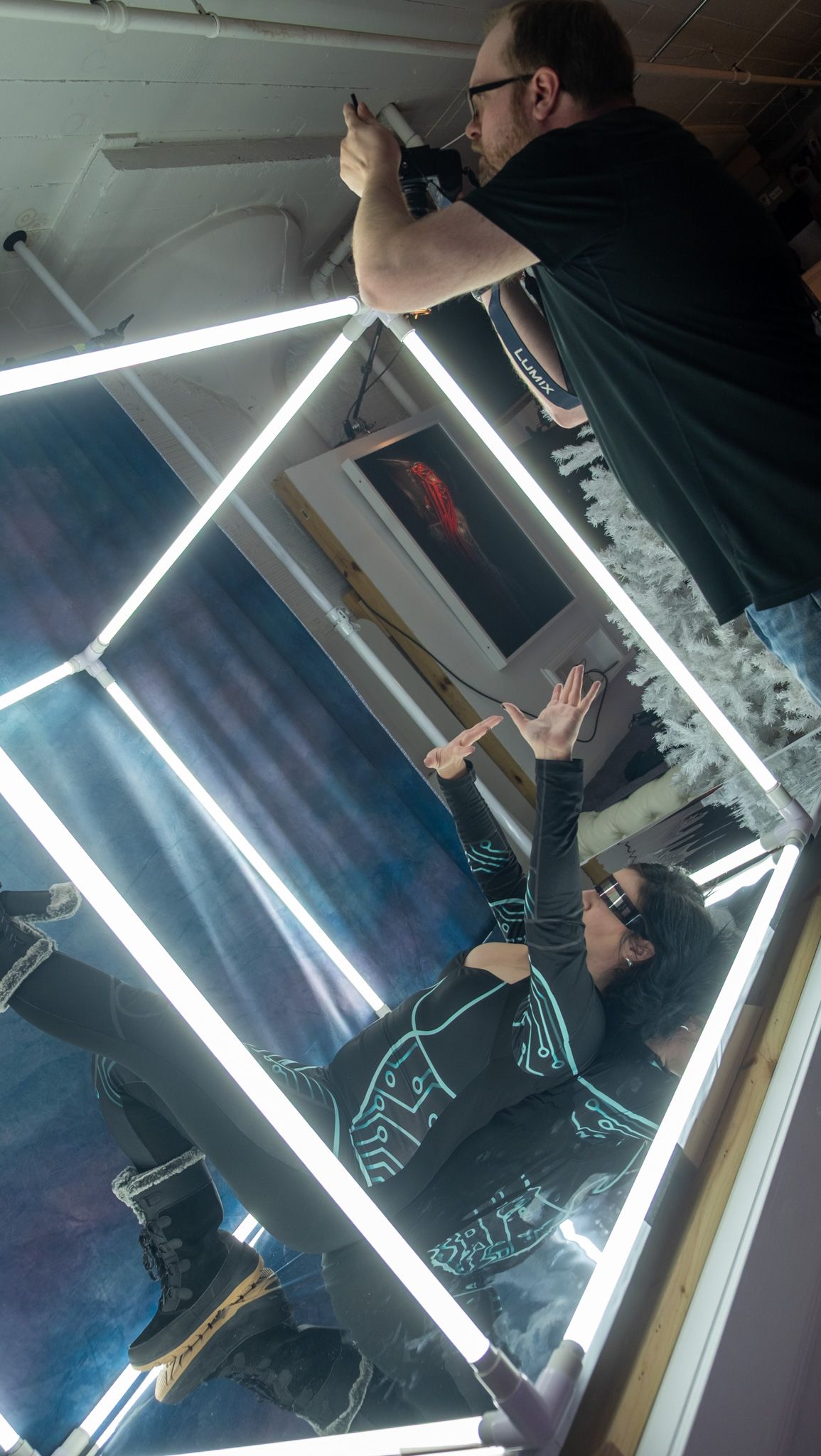 A sequence of photos showing fluorescent light fixtures being installed in an angular geometric pattern on a dark wall.