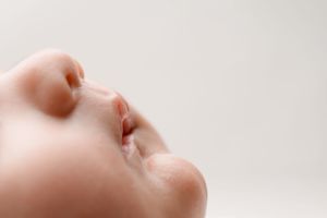 Close-up profile view of a baby's nose and mouth against a light background.