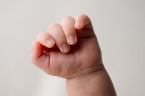 Four sequential images showing a hand forming a fist, demonstrating the progression of fingers closing into a grip.