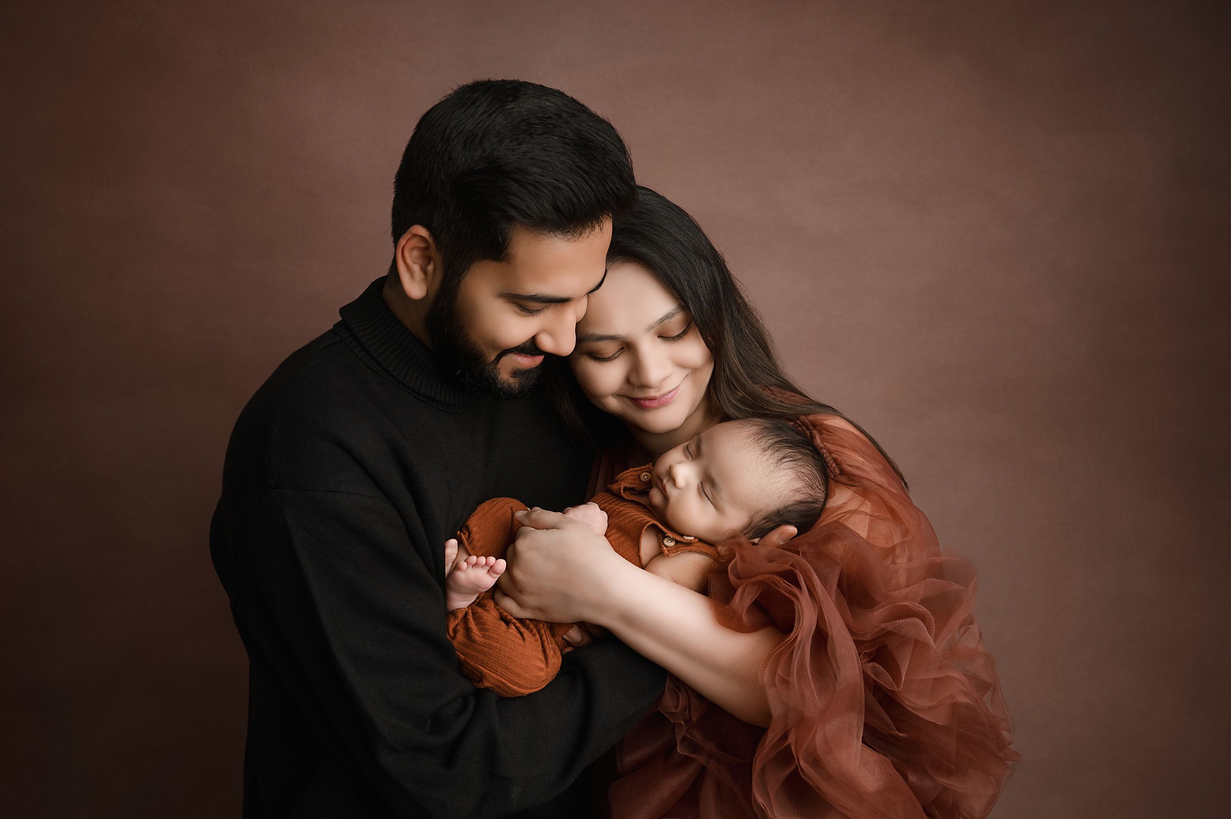A romantic couple embraces intimately in a dark moody setting with dramatic lighting and warm tones.