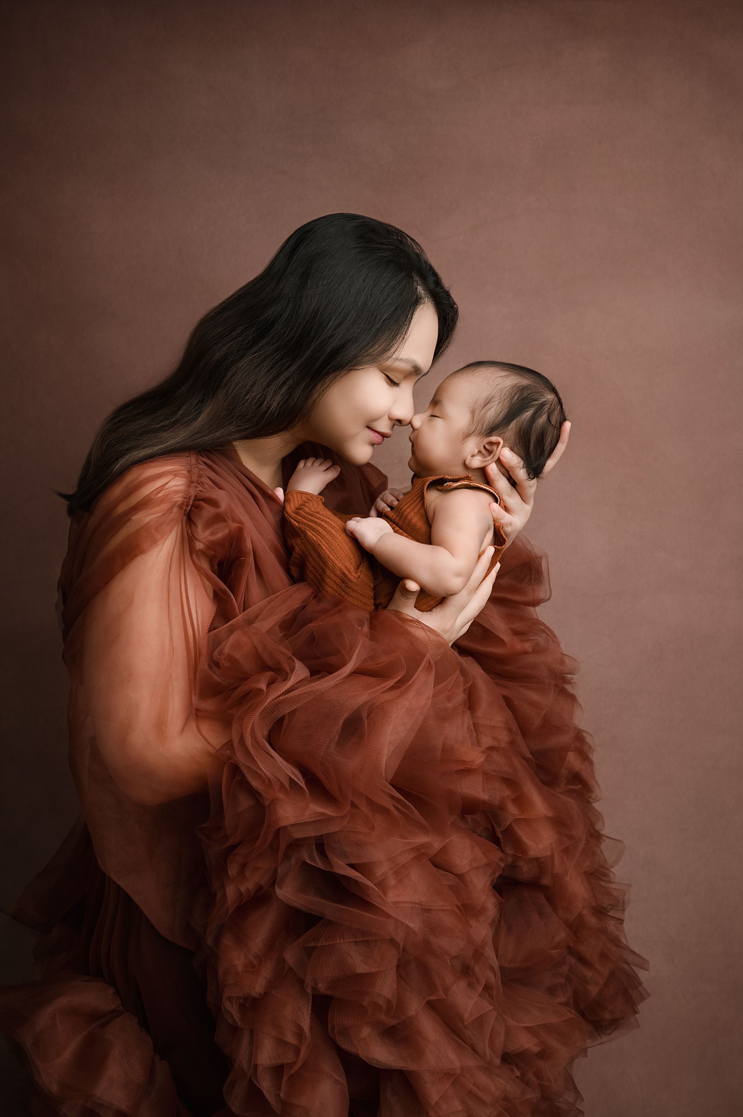 A series of artistic portraits showing a figure in a flowing rust-colored ruffled dress against a dark brown backdrop.