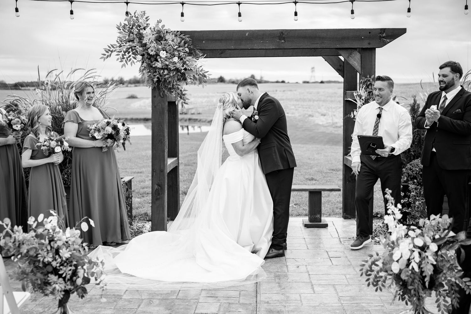 Black and white wedding photo collage showing romantic moments between newlyweds during outdoor beach ceremony.