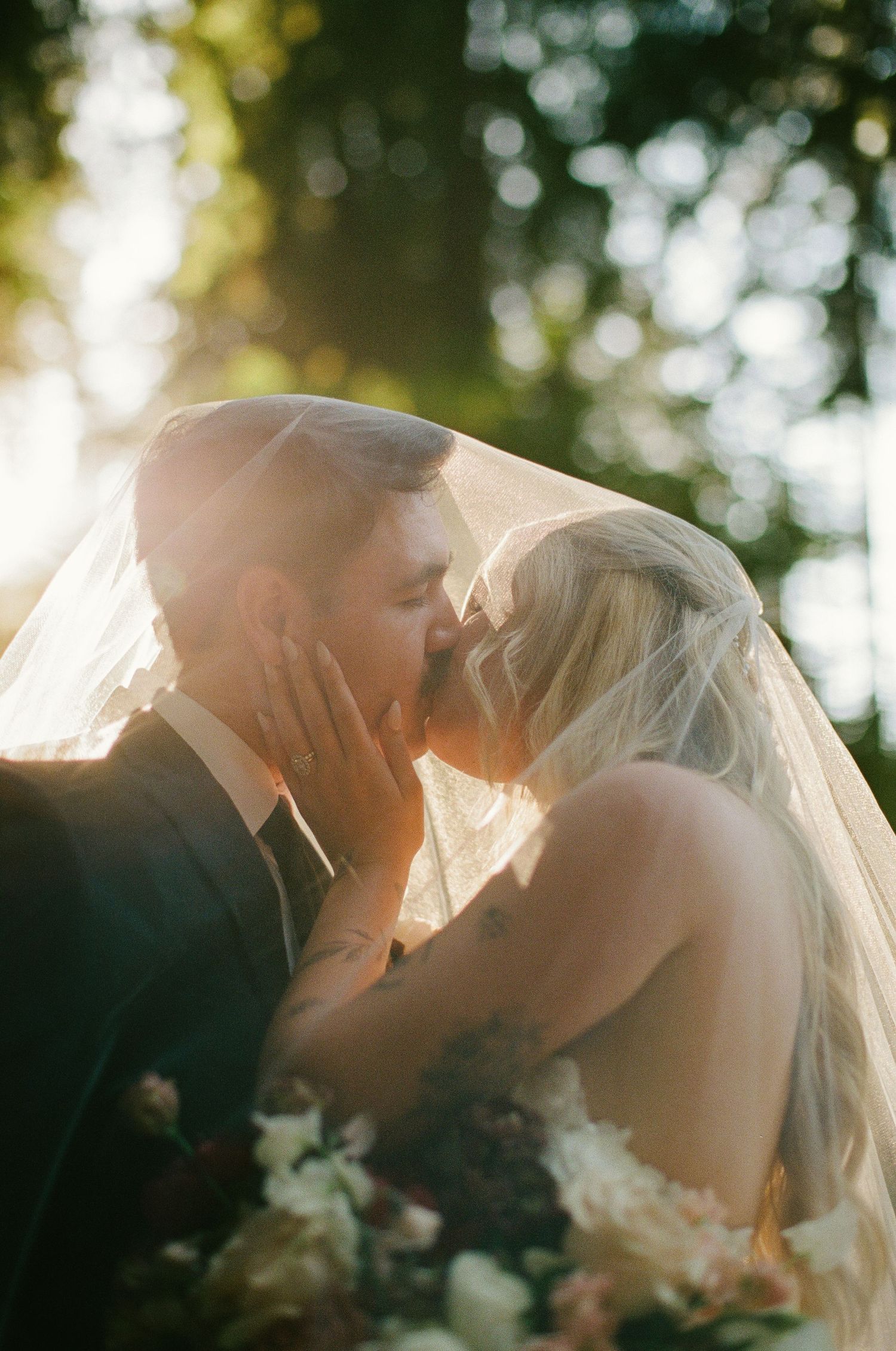 Newlyweds celebrate with guests during outdoor garden wedding ceremony with white chairs and natural backdrop.