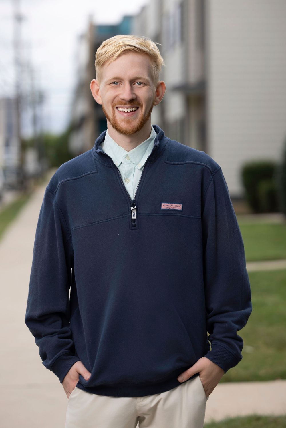 A series of casual portraits showing someone in a navy quarter-zip pullover against a light building exterior.