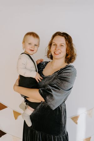 Warm family portrait with decorative triangle bunting in the background.