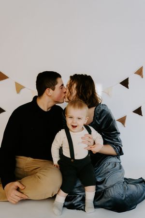 Intimate family moment captured in soft lighting with decorative banners.