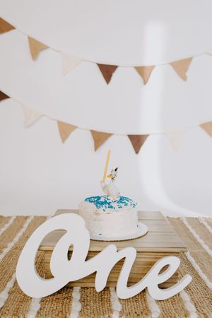 First birthday party setup with white lettering and bunting decorations.