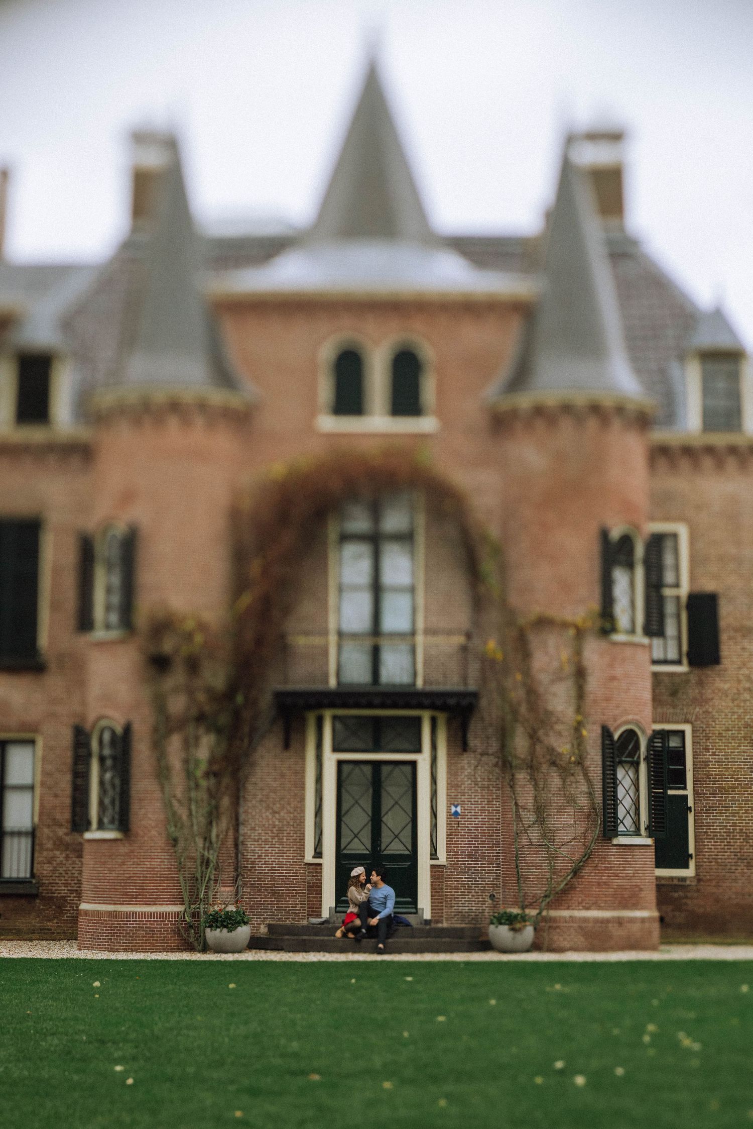Wide shot of a fairytale-style castle with towers and green lawn used for proposal photoshoots in the Netherlands