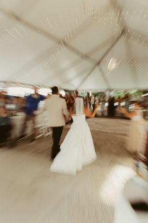 Artistic motion blur photo of bride and groom dancing at tented wedding reception.