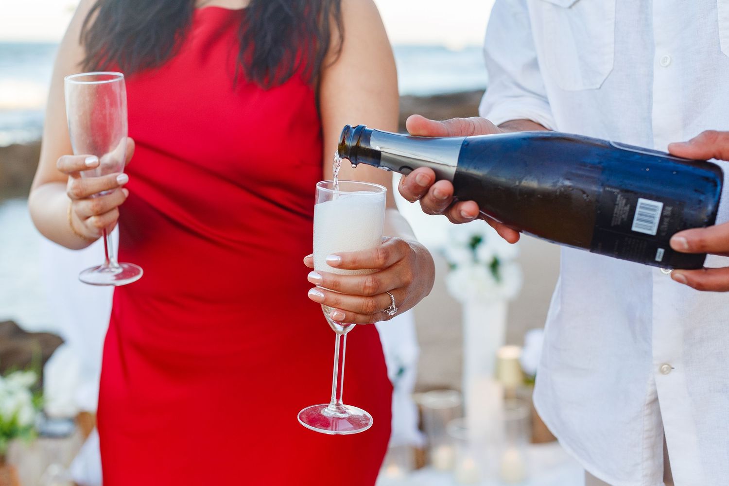 Couples portrait. Proposal and engagement session. Man and woman on the beach. Pouring champagne. Kikita Surf Beach, Dorado, Puerto Rico.
