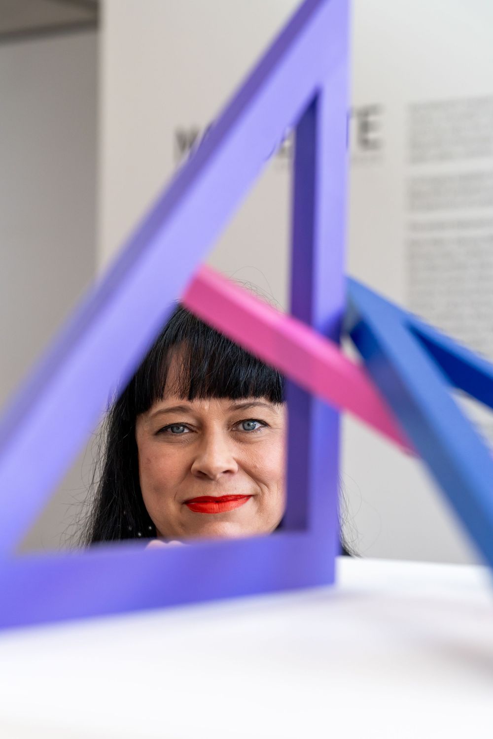 A creative portrait composition using purple geometric shapes framing a partial view through triangular spaces.