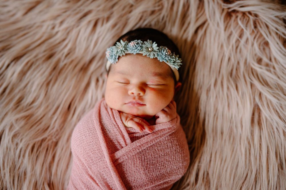 A collage of six newborn baby photos showing peaceful sleeping poses on soft pink and cream textured backgrounds.