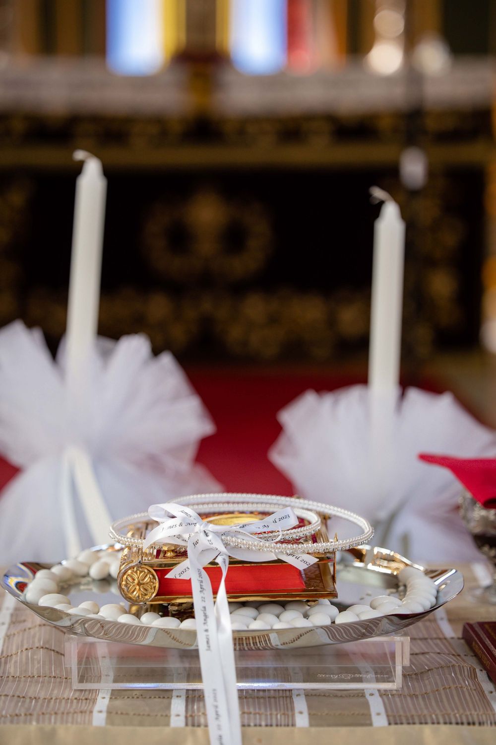 Greek Orthodox wedding crowns and rings displayed on ceremonial silver tray.