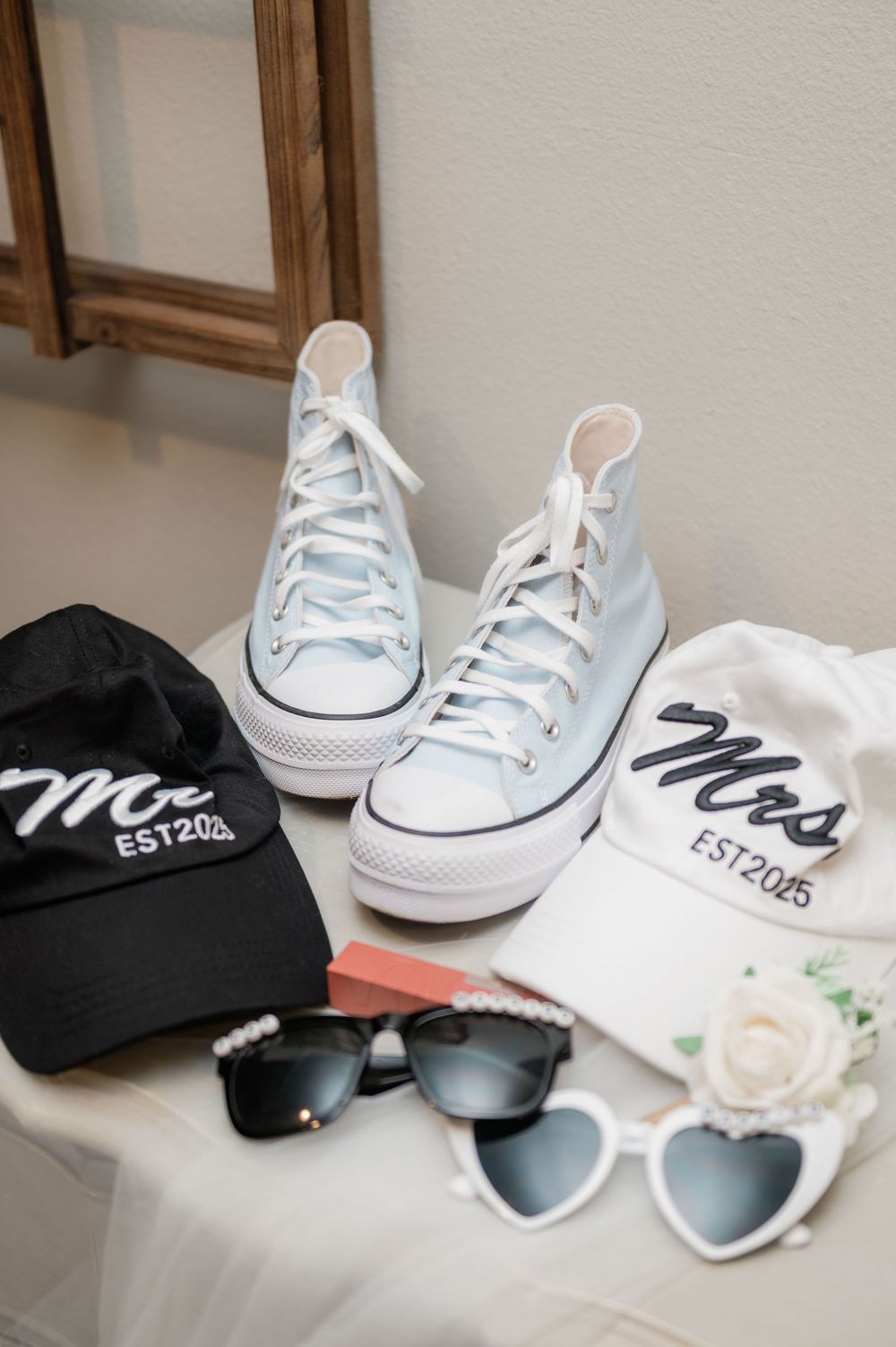 Wedding accessories including light blue Converse sneakers, matching Mr and Mrs baseball caps, and heart-shaped sunglasses.