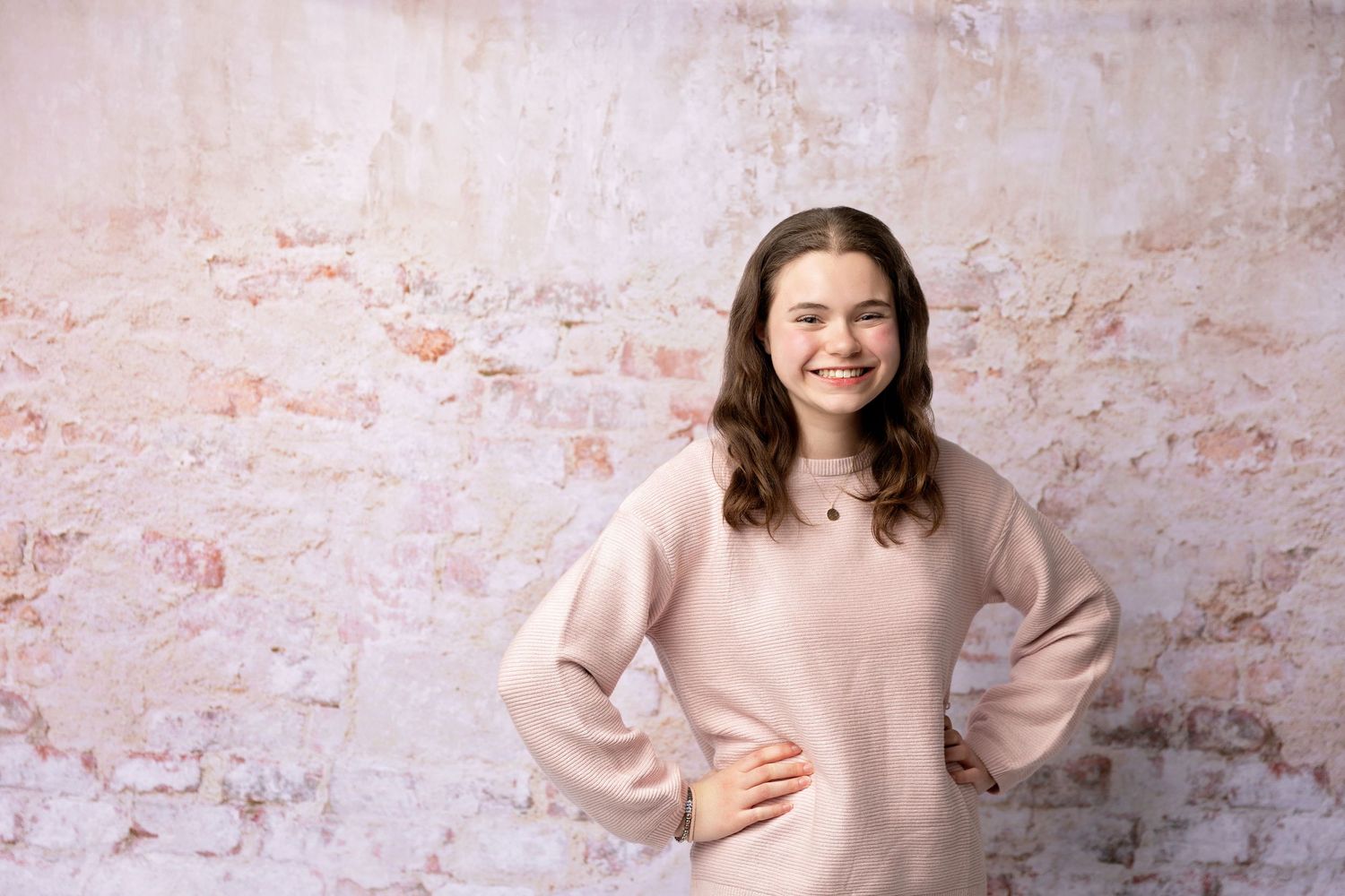 Studio senior portrait of a high school senior in a pink sweater, photographed by a New Hampshire senior photographer in the Lakes Region