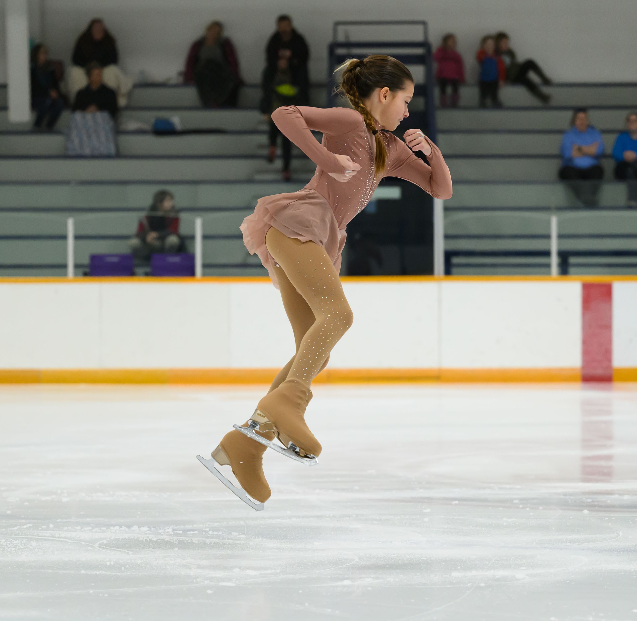 Figure skater performs a graceful jump sequence on ice during competition, captured in multiple action frames.