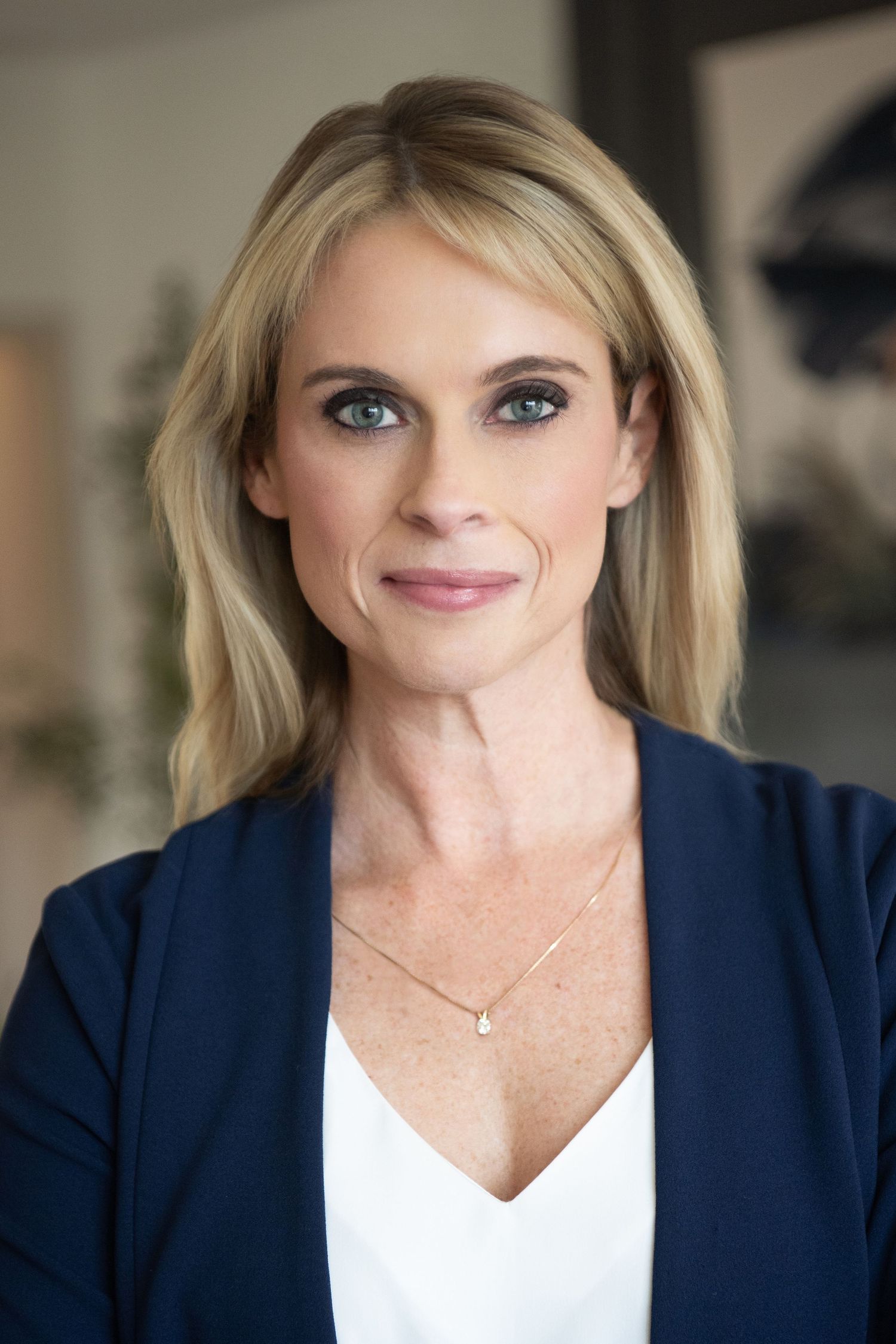 Professional headshot series showing person in blue button-down shirt with arms crossed against neutral background.